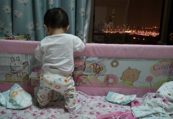 寶貝女兒靠著欄杆看夜景